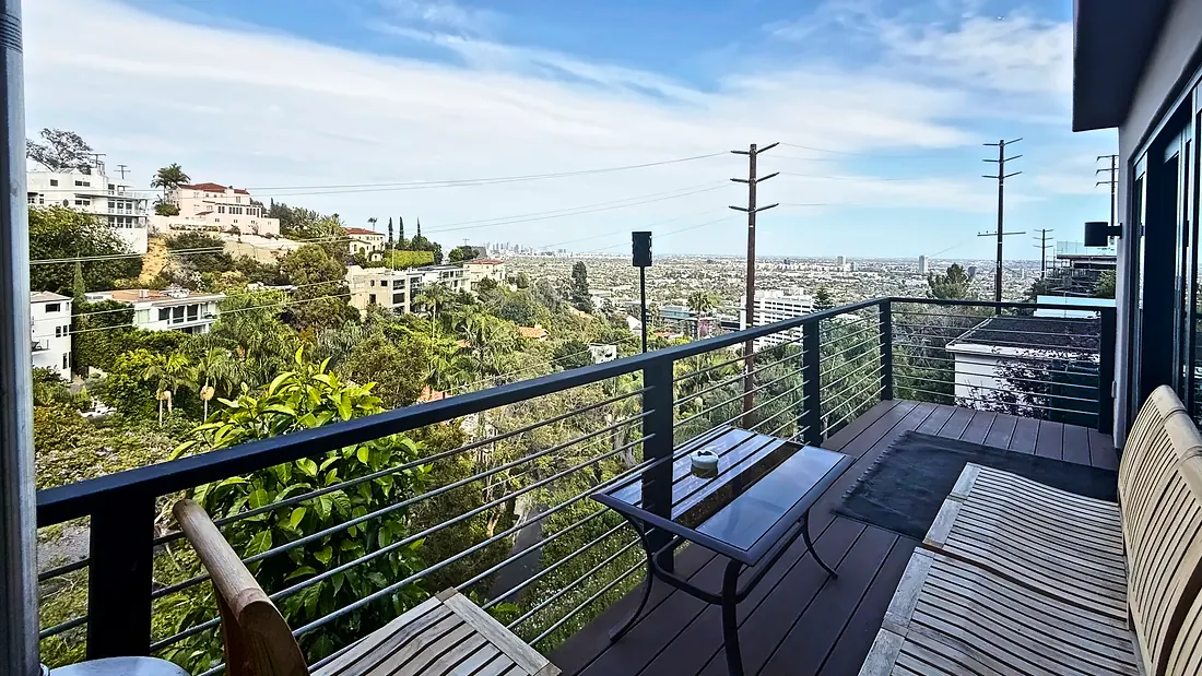 Deck with lounge chairs over the canyon and the city