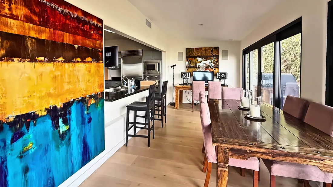 Dining room with a long wood table beside the open kitchen